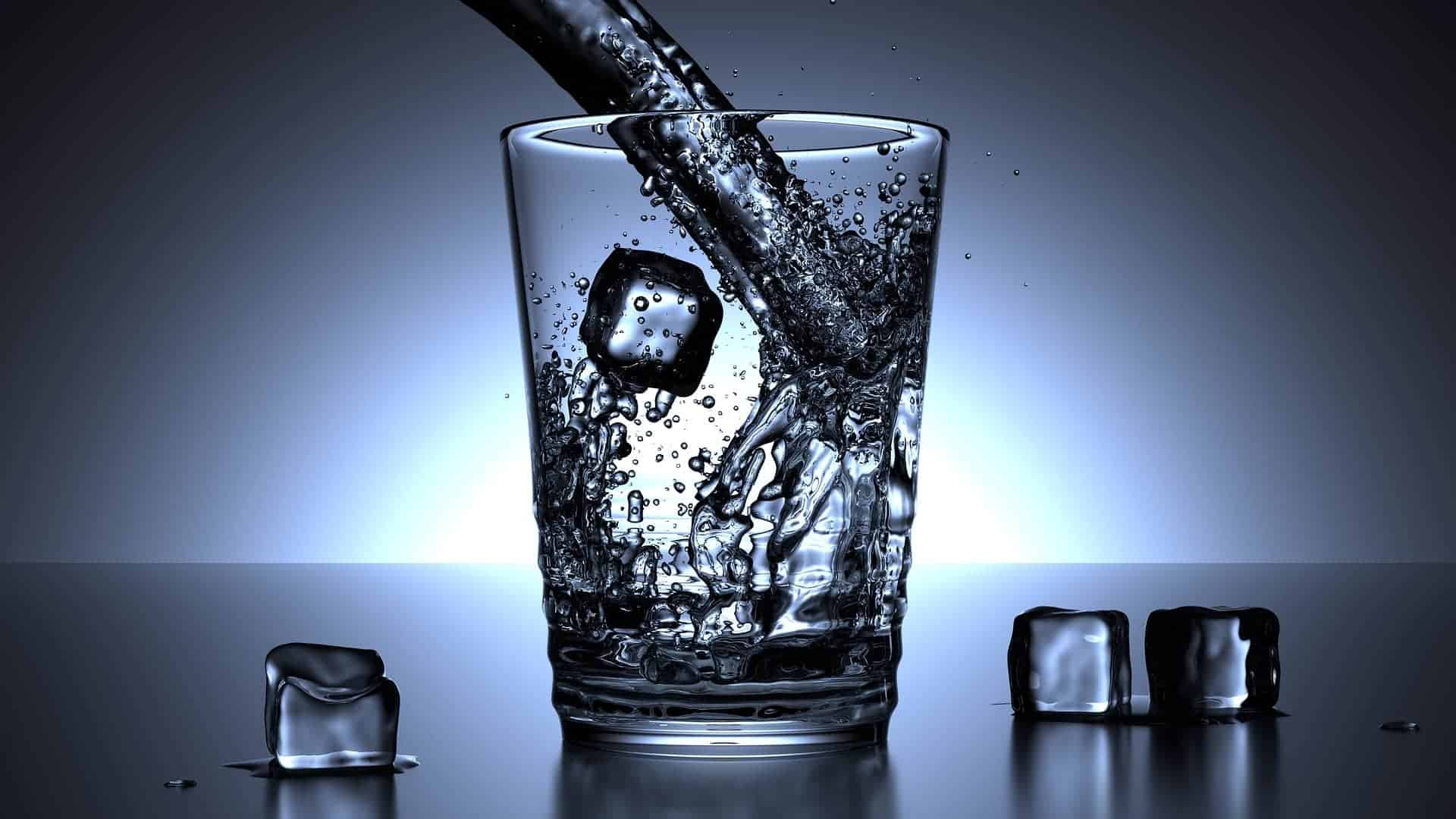 pouring water from a sparkling water dispenser into a glass