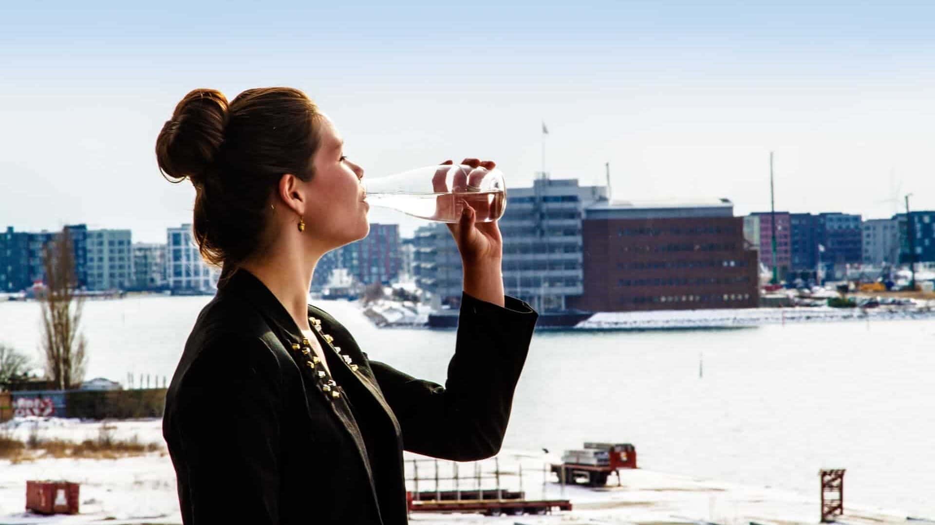 woman drinking water from a reusable bottle